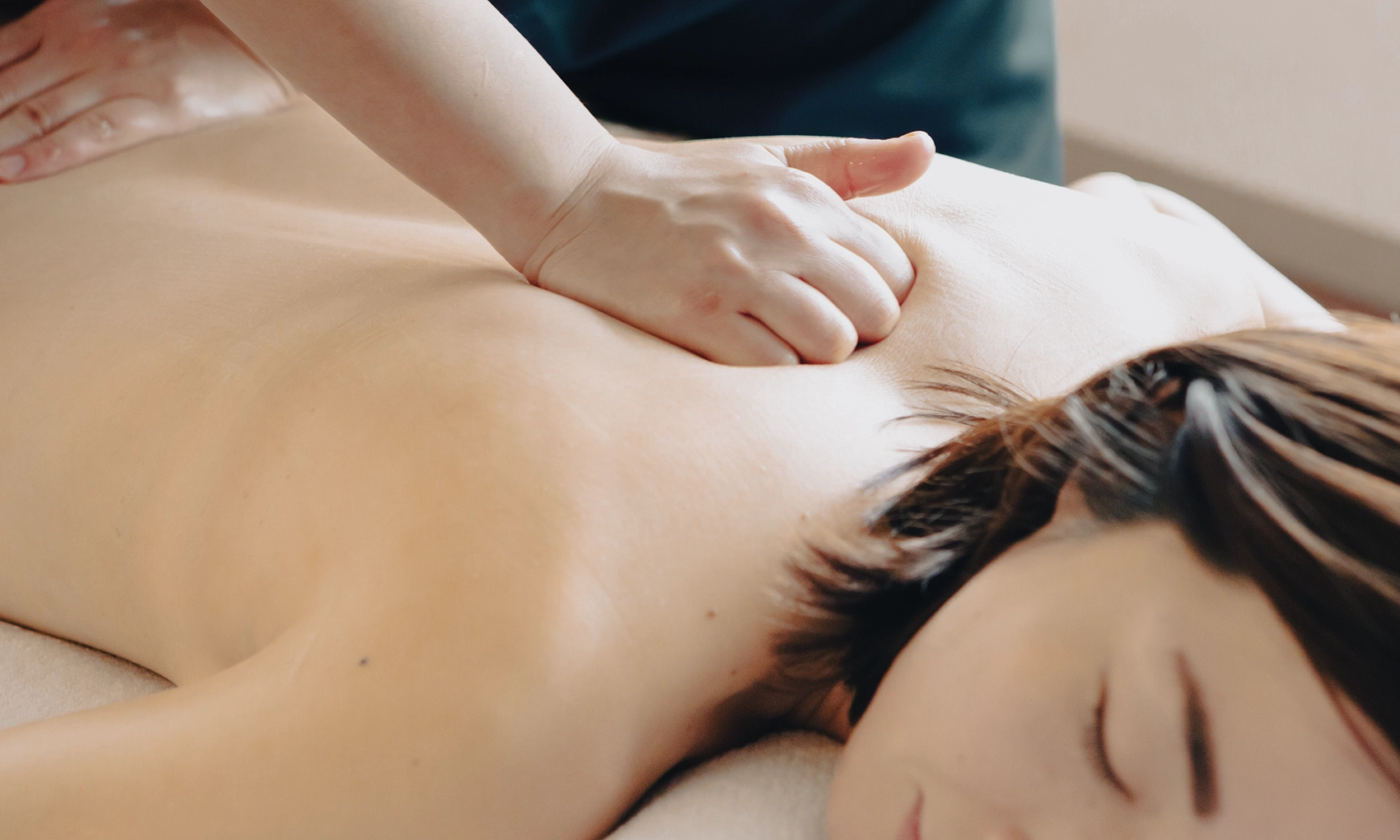 Therapist applying deep, focused pressure to the back with body weight